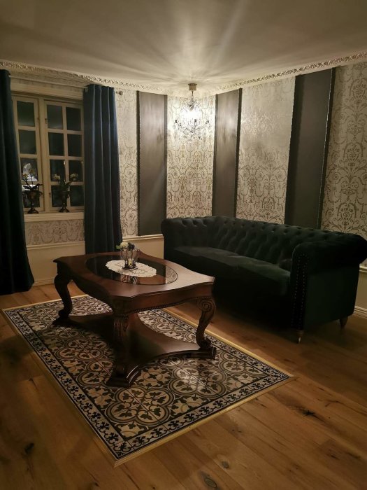 Elegant inrett tv-rum med klassisk soffa, dekorativ matta och mörka draperier.