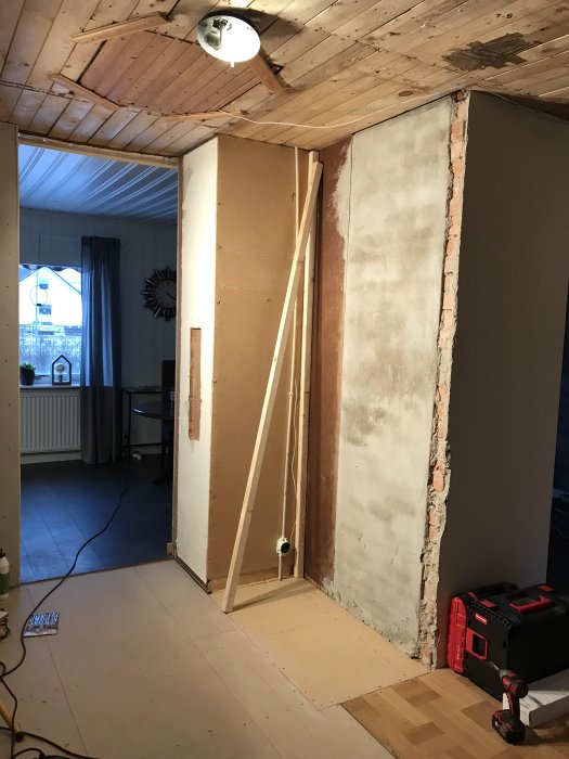 Rum under renovering där gamla garderober tagits bort, exponerade väggar och verktyg syns.