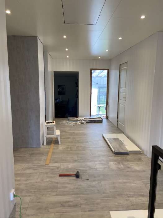 Installation av vattentåligt vinylklickgolv i en ljus och rymlig interiör.
