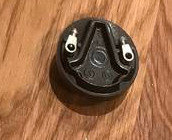 En svart elektrisk anslutning upp-och-ned på ett träbord.
