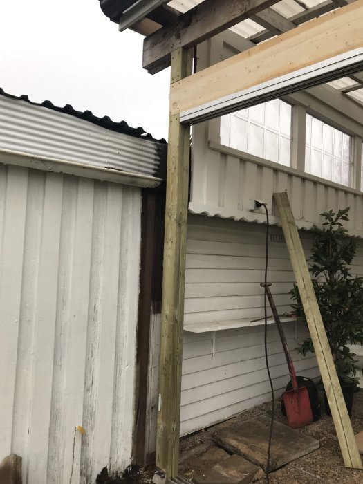 Renovering av uterum med nya trästolpar och konstruktion för skjutpartier.