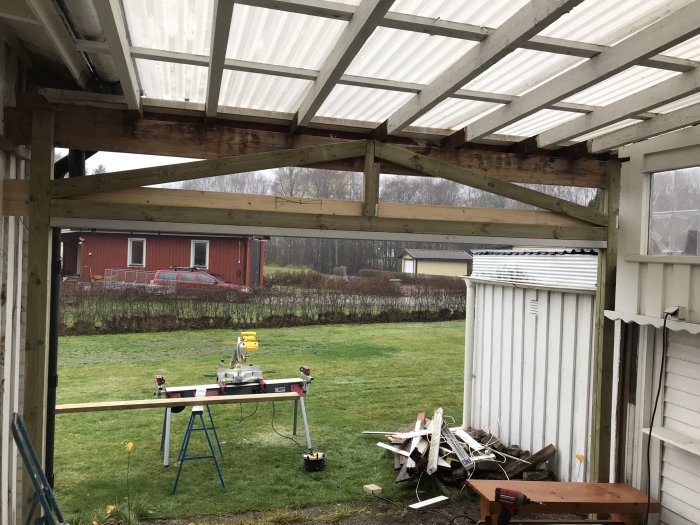 Renovering av uterum med nya träkonstruktioner, verktyg och material syns.