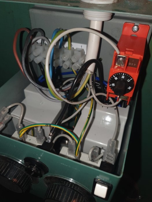 Intern vy av en termostat med elektriska komponenter och rött reglage märkt med "Sec" inställt på 180.