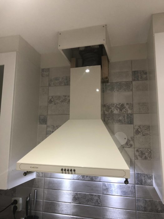 Ny Klarstein Victoria köksfläkt monterad mellan skåp utan dekorationsrör mot taket.