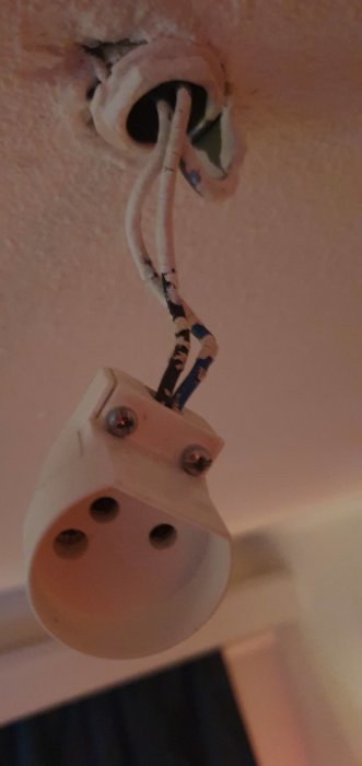 Skadat takuttag efter dimbar LED-lampa brunnit, synliga brännmärken och kablar.
