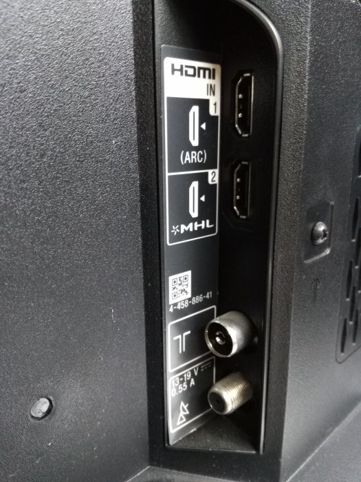 Anslutningsportar på en TV med HDMI- och antenningångar, märkta för ARC och MHL-kompatibilitet.
