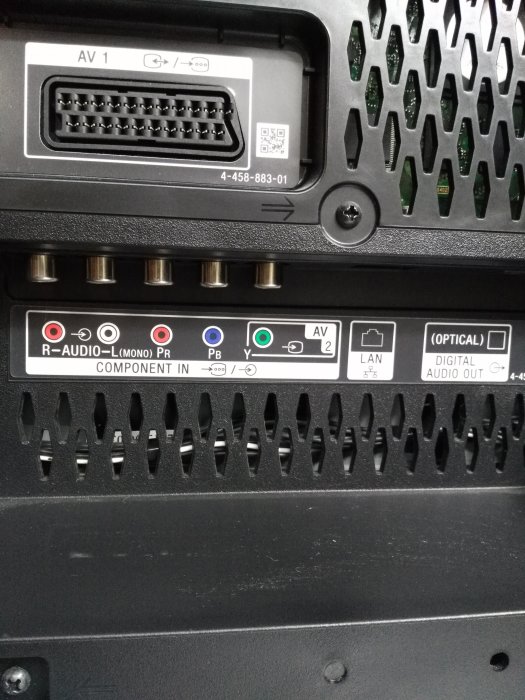 Anslutningspanel på baksidan av en TV med olika portar inklusive SCART, komponent och ljudingångar.