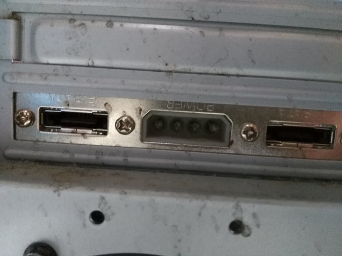 Anslutningsportar på baksidan av en gammal dator, inklusive USB, Ethernet och andra portar, smutsiga och använda.