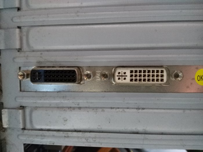 Närbild på baksidan av en dator med en DVI, en parallellport och en VGA-anslutning mot en grå bakgrund.