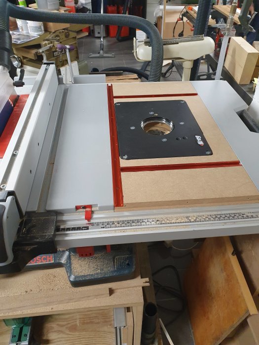 Monterad färdig fräsplatta i snickeriverkstad med verktyg och arbetsbänkar runtomkring.