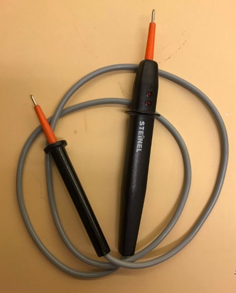 Spänningsprovare med grå kabel och svart handtag, verktyg för att mäta elektrisk spänning.