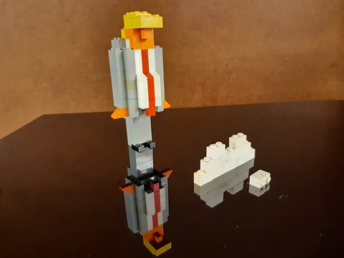 LEGO-figur föreställande en karaktär med grå kavaj, orangerött slips, och gul hårsvall.