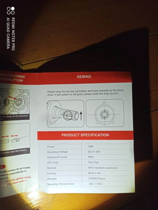 Bild på en produktmanual för bilbelysning med specifikationer och instruktioner på en bordsskiva.