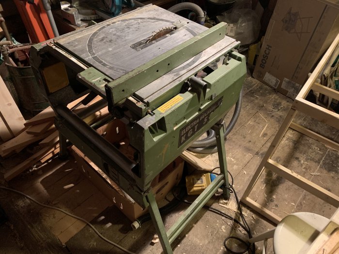 Använd Elektra Beckum KGT 500 geringssåg i ett rörigt garage, dammutsug saknas, fäste sprucket.
