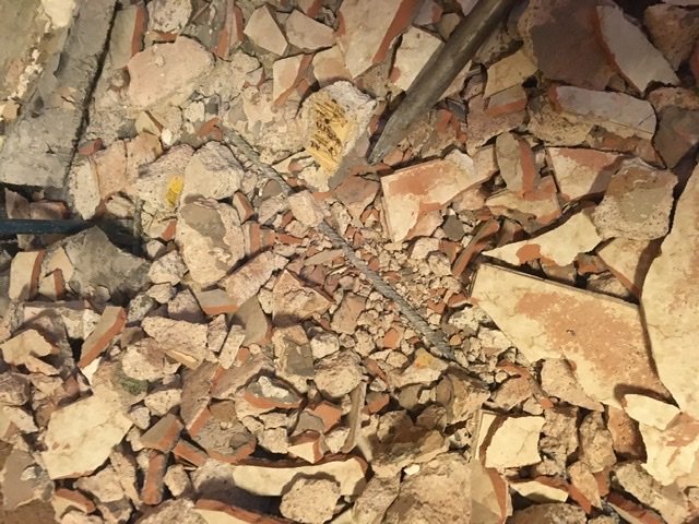 Nya sprickor i cirka 10 cm breda bjälkar omgivna av sönderbrutet tegel och betong.