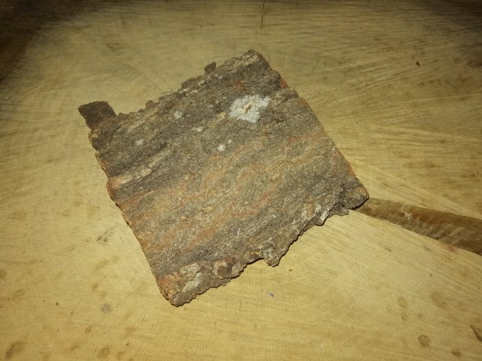 Övergiven trästubbe med bark, som ska återanvändas som sidobord, på ett ljust träunderlag.