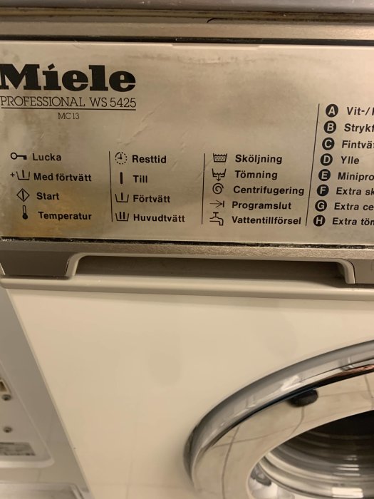 Närbild av kontrollpanelen på en Miele Professional WS 5425 tvättmaskin med flera funktionsikoner.