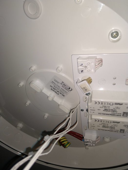 Baksidan av en rund LED-plafond med elektriska anslutningar och installationsdetaljer synliga.