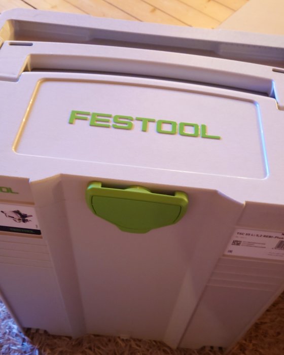 Festool systainer med logotyp synlig och grönt handtag, står på ett golv.