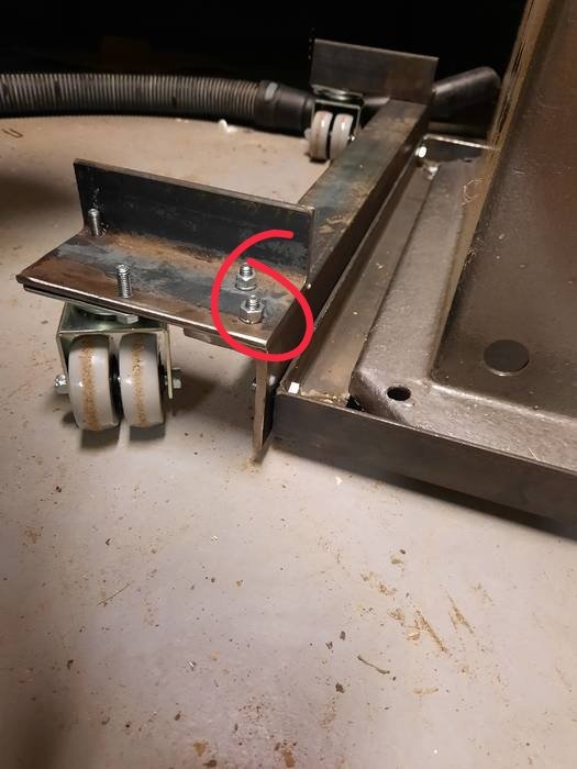 Metalldel med vinkeljärn och bultar markerat i rött, föreslaget för justering.