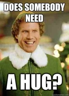 Person utklädd till Buddy från filmen "Elf" med texten "Does somebody need a hug?