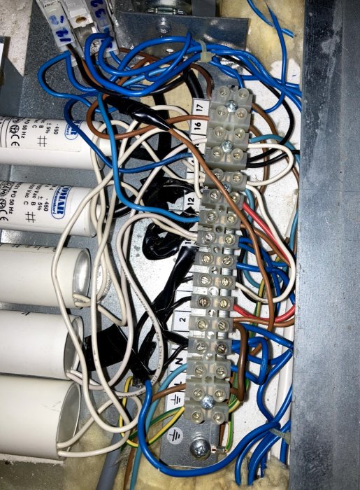 Oorganiserad kabeldragning med olika färgade kablar kopplade till en numrerad kopplingslist i ett Flexit VGL-400-aggregat.