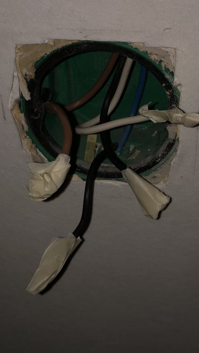 Eluttag med avskalade, tejpade svarta, bruna och beigea kablar samt en otejpad blå kabel, redo för ny dimmerinstallation.