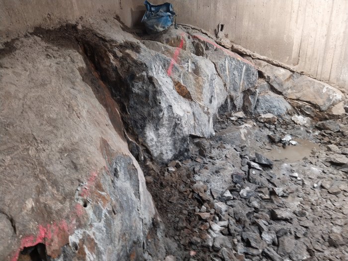 En stor spräckt bergsdel med lösa stenfragment och märkningar, resultat av sprängningsarbete.