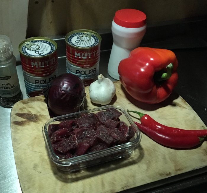 Ingredienser för älgchili, inklusive älgkött och grönsaker på en skärbräda.