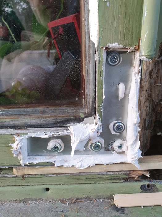 Skador på en fönsterkarm lagad med 2-komponents finspackel, med tecken på rötskador och pågående renoveringsarbete.