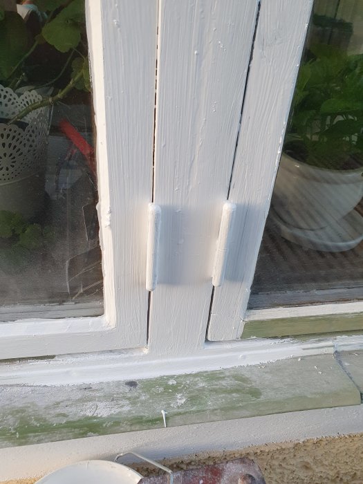 Reparation av fönsterkarm med spackel för att fixa rotskador, målad i vitt.