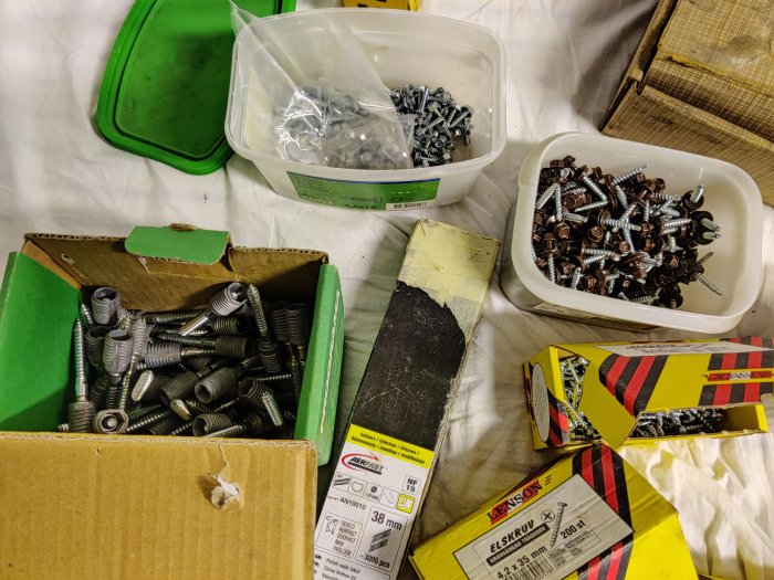 Olika sorters skruvar i förpackningar och lösa i behållare, bandad spik i låda säljs separat.