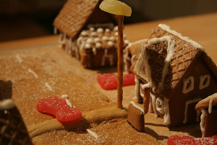 Pepparkakshus nära en ätpinne-lyktstolpe och vägbula gjord av godis på ett bagerigatuprojekt.