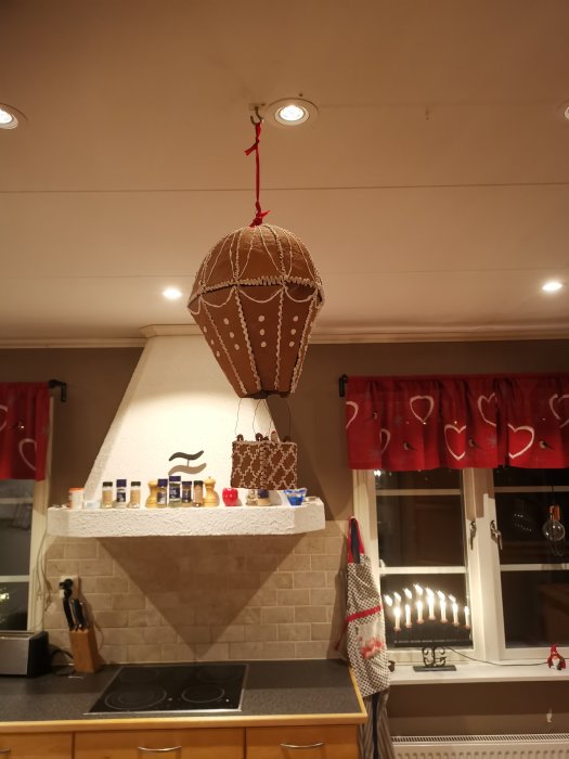Handgjord pepparkaksballong hängandes i köket, med dekorativa detaljer och en korg.