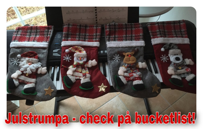 Fyra julstrumpor med olika figurer: tomte, snögubbe, ren och isbjörn, på en bänk med text om bucketlist.