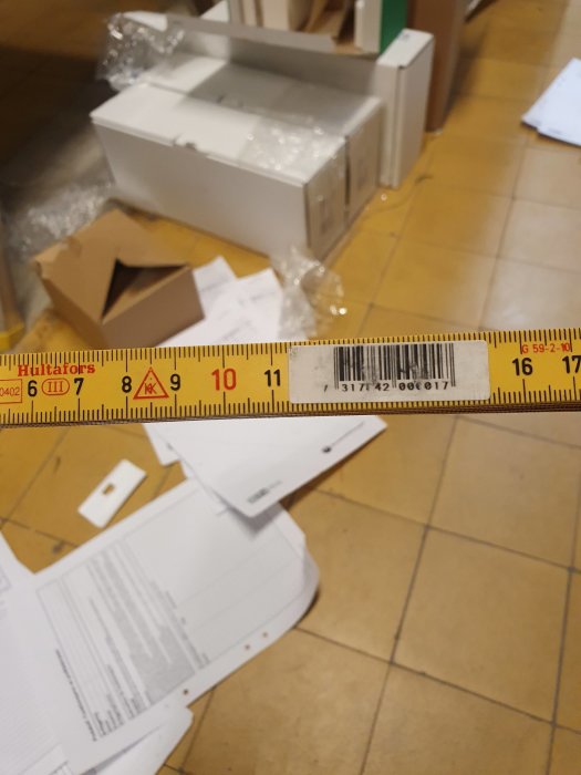 Tumstock märkt med Hultafors på ett golv med öppnad kartong och förpackningsmaterial.