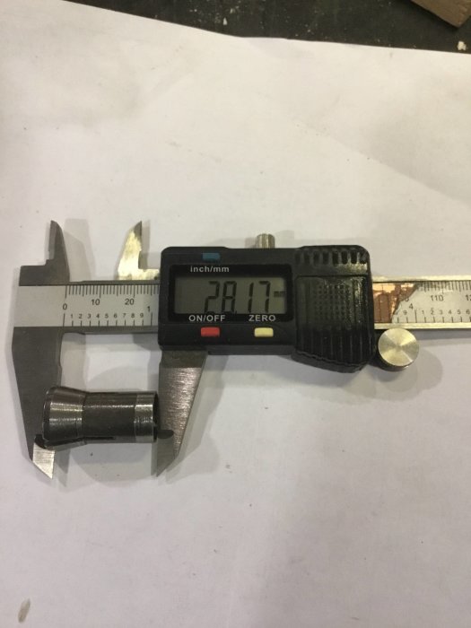 Digital skjutmått visar 31.17 mm vid mätning av en maskinkomponents diameter.