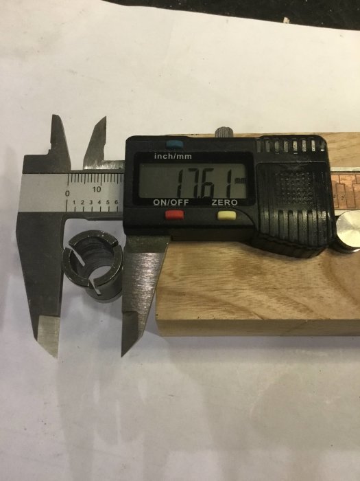 Digital skjutmått visar 16.51mm vid mätning av metallylsans diameter på träyta.