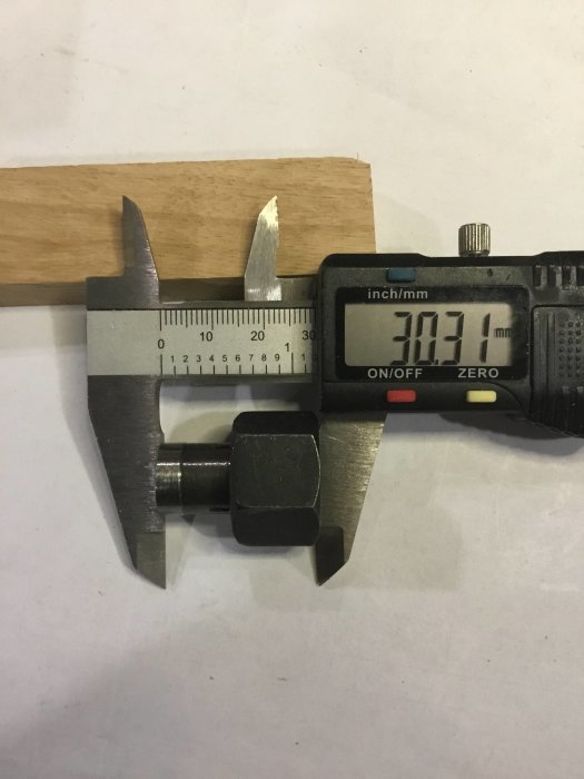 Skjutmått mäter diametern på en maskindel med en visad storlek på 13,71 mm.