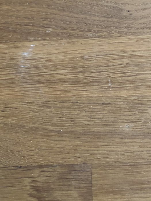 Trägolv med spilld vit färg som dokumentation av slarvigt hantverksarbete.