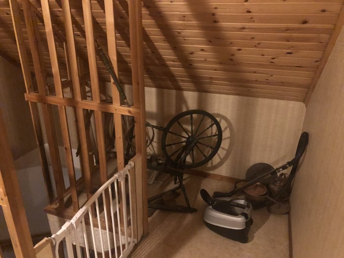 En trappa med träspaljé och ett barnskydd, oinredd yta med ett gammalt hjul och sadel, potentiellt farlig för småbarn.