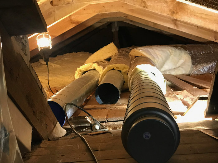 Installation av ventilation på vind med flexrör och isolering i ett lågt utrymme.