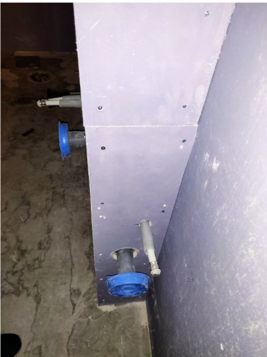 Våtrumsvägg med för stora mellanrum runt avloppsrör och vattentillförsel enligt GVK-regler.