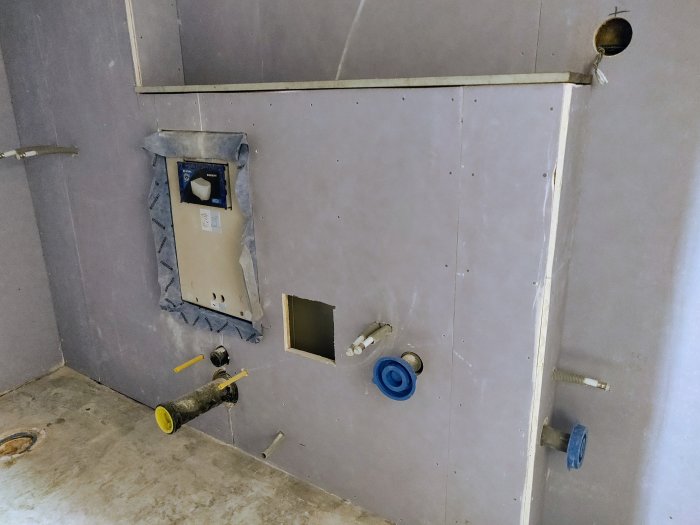 Vägg med flera rörgenomföringar och ett toalettmonteringsställ, avstånd verkar överskrida 2mm regel.