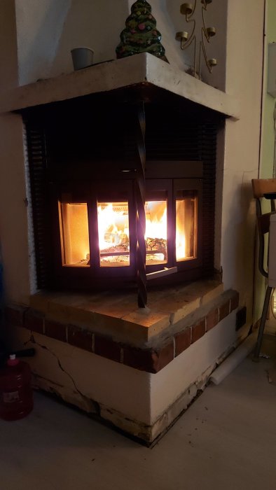 Nymonterad Jötul c400 Harmony-kamin med brinnande eld, väntar på golvplatta.