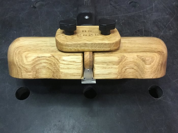 Handgjord trärouter plane med böjd, ergonomisk design och utbytbara stålskär.