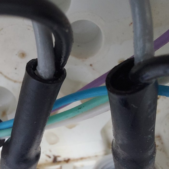 Kablars ändar täta med krympslang och vaselin, i installationsdosa, med några synliga ledningar.