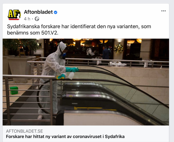 Person i skyddskläder desinficerar rulltrappans räcke i ett köpcentrum.
