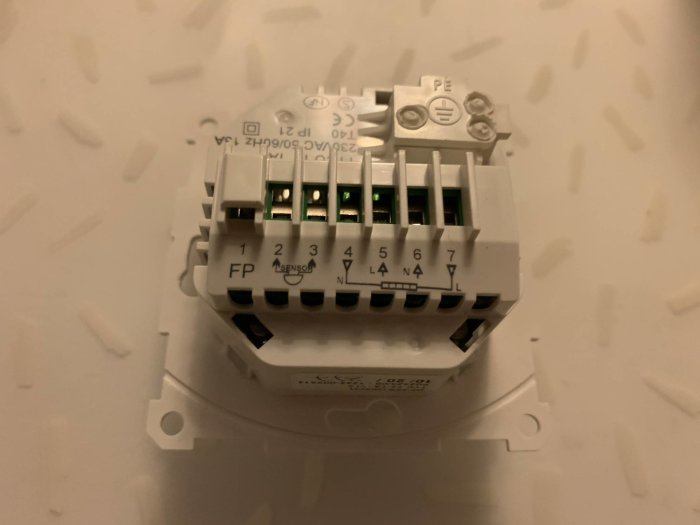 Ny termostat med kopplingsterminaler, numrerade för installation, på vit bakgrund.