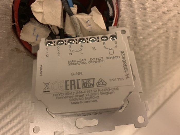Ny termostat installerad på vägg med ledningar anslutna enligt numrerade klemmor.